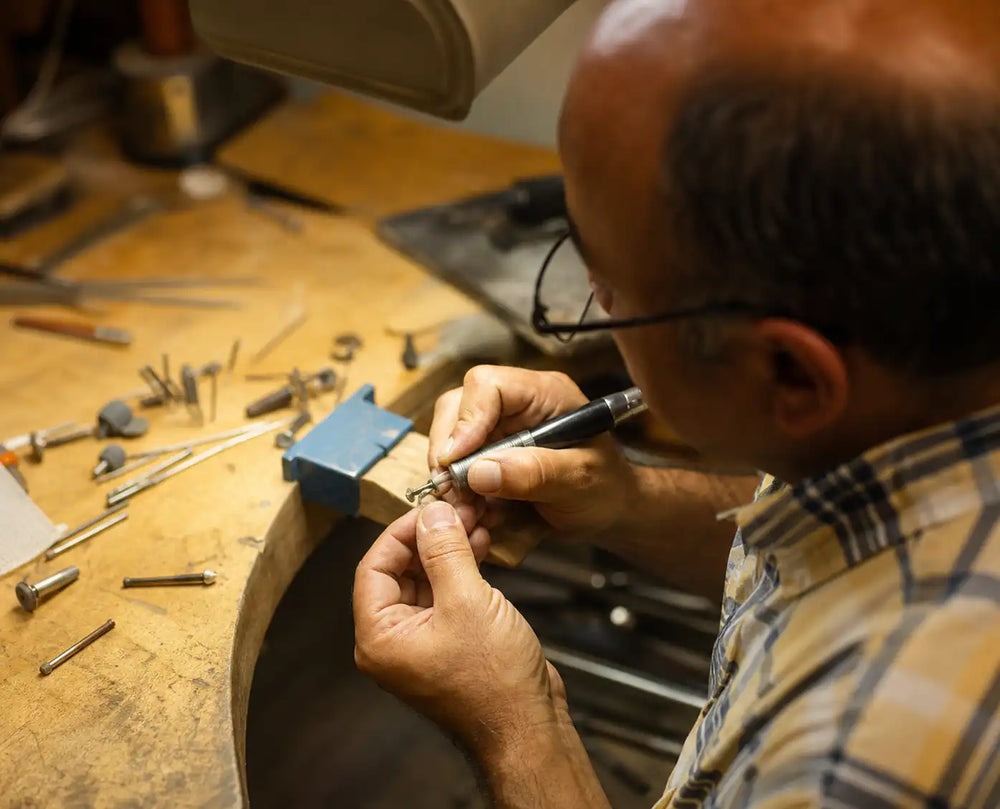 Jeweler performing a jewelry repair at the Lustig workbench